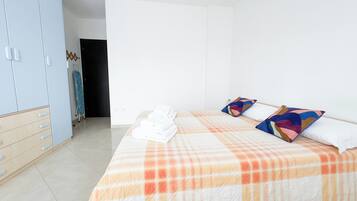 A hotel room with a bed, a wardrobe, and a door.