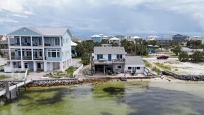 A coastal residential area with houses, a dock, and a body of water. - Panferio Paradise, Water Front Home (Pensacola Beach)