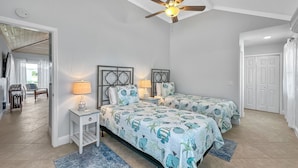 A bedroom with two beds, a ceiling fan, and a view of a balcony. - Golf Cart Included, Bimini Villa, Treasure Cay, Bahamas, 100 yards from beach (Treasure Cay)