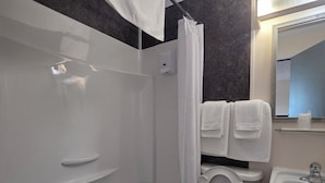 A bathroom with a bathtub, toilet, sink, and a shower curtain. - Motel Claude (Degelis)