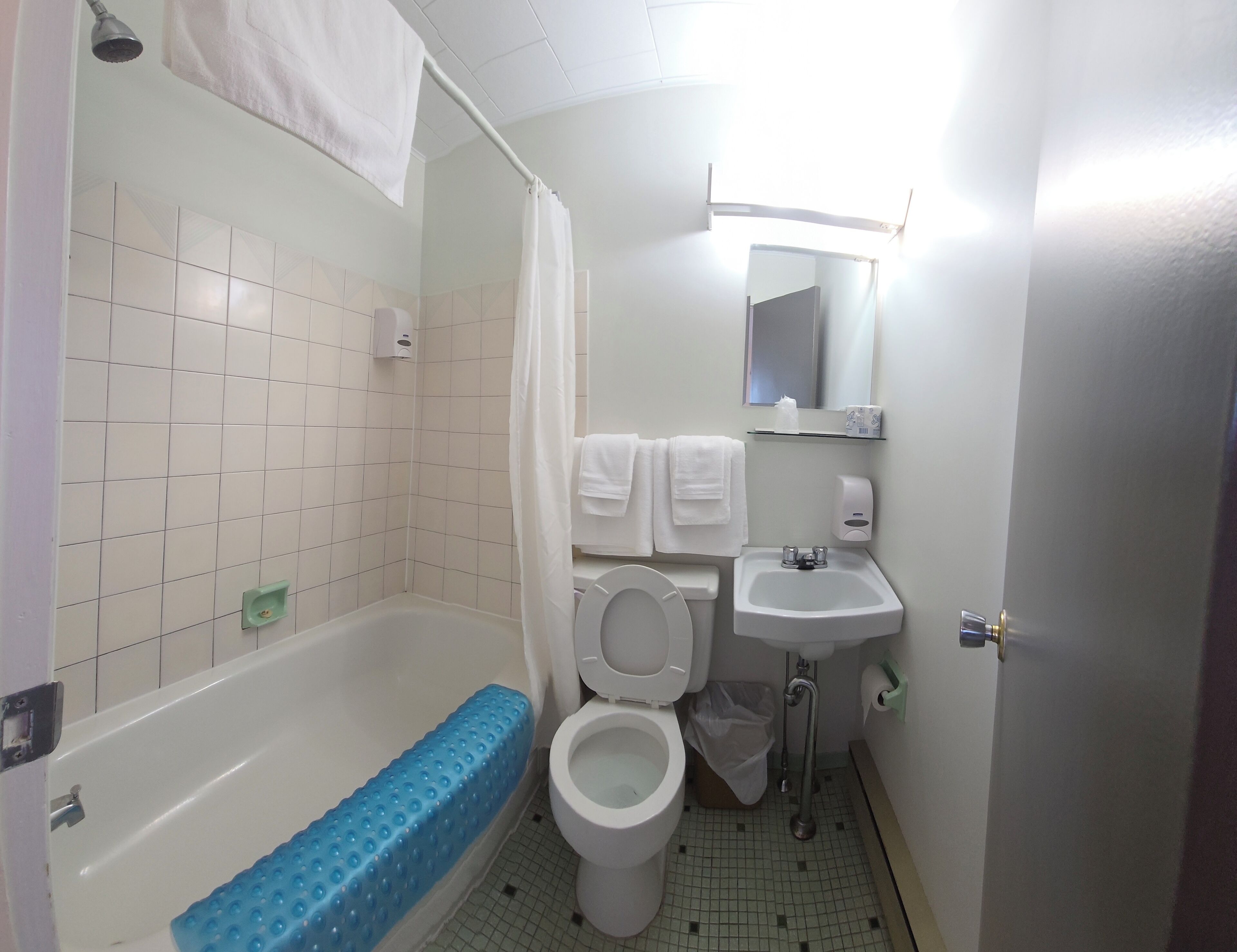 A small bathroom with a bathtub, toilet, and sink.