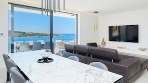 A modern living room with a large dining table, a sofa, and a TV mounted on the wall. - Hedera Estate, Hedera A25 (Lozica)