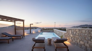 Un espace piscine aménagé sur le toit, avec des chaises longues et une pergola.
