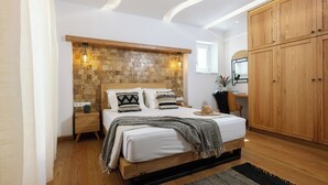 Une chambre à coucher avec un lit en bois, un mur en pierre et des armoires en bois.