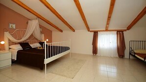 Una camera da letto con un letto, un comodino e una finestra con tende.