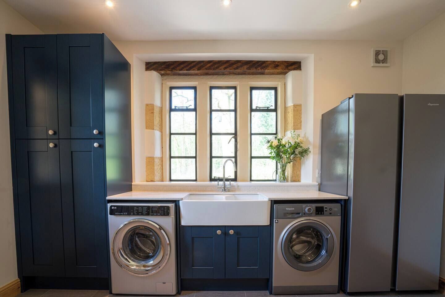 A compact kitchen with a built-in washer and dryer, a sink, and a refrigerator.