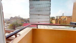 A view from a balcony with a metal railing, overlooking a cityscape with buildings of various architectural styles, including a distinctive tower with a unique facade. - gA Distintivo Loft en Cabrera (Bogotá)