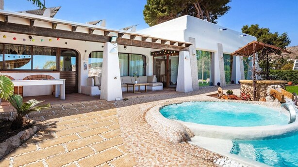 Een moderne villa met zwembad, terras en een pergola.