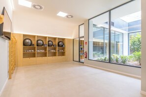 Enjoy the open space with a high ceiling, shelving, and a large glass door leading to a scenic outdoor area.