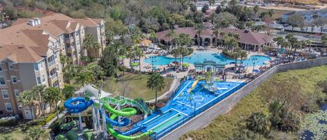 A resort with multiple swimming pools, a water park, and a large building with balconies.
