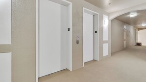 A hallway with white doors, numbered 2, and a fire alarm on the wall. - Disney 2 miles w/Heated Pool, water park, basketball tennis courts,  game room  (Kissimmee)