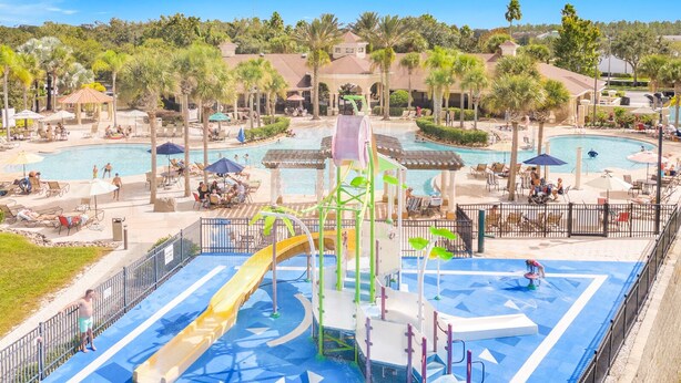 A water park with multiple pools, slides, and a play area with a slide and climbing structure. - Disney 2 miles w/Heated Pool, water park, basketball tennis courts,  game room  (Kissimmee)