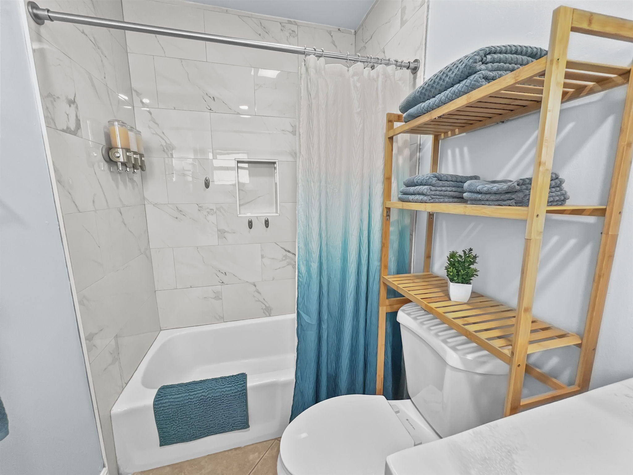 A modern bathroom with a glass shower enclosure, a bathtub, a toilet, and a wooden shelf with towels.