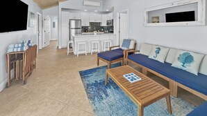 Een moderne woonkamer met een houten plafond, een bank, een salontafel en een televisie.