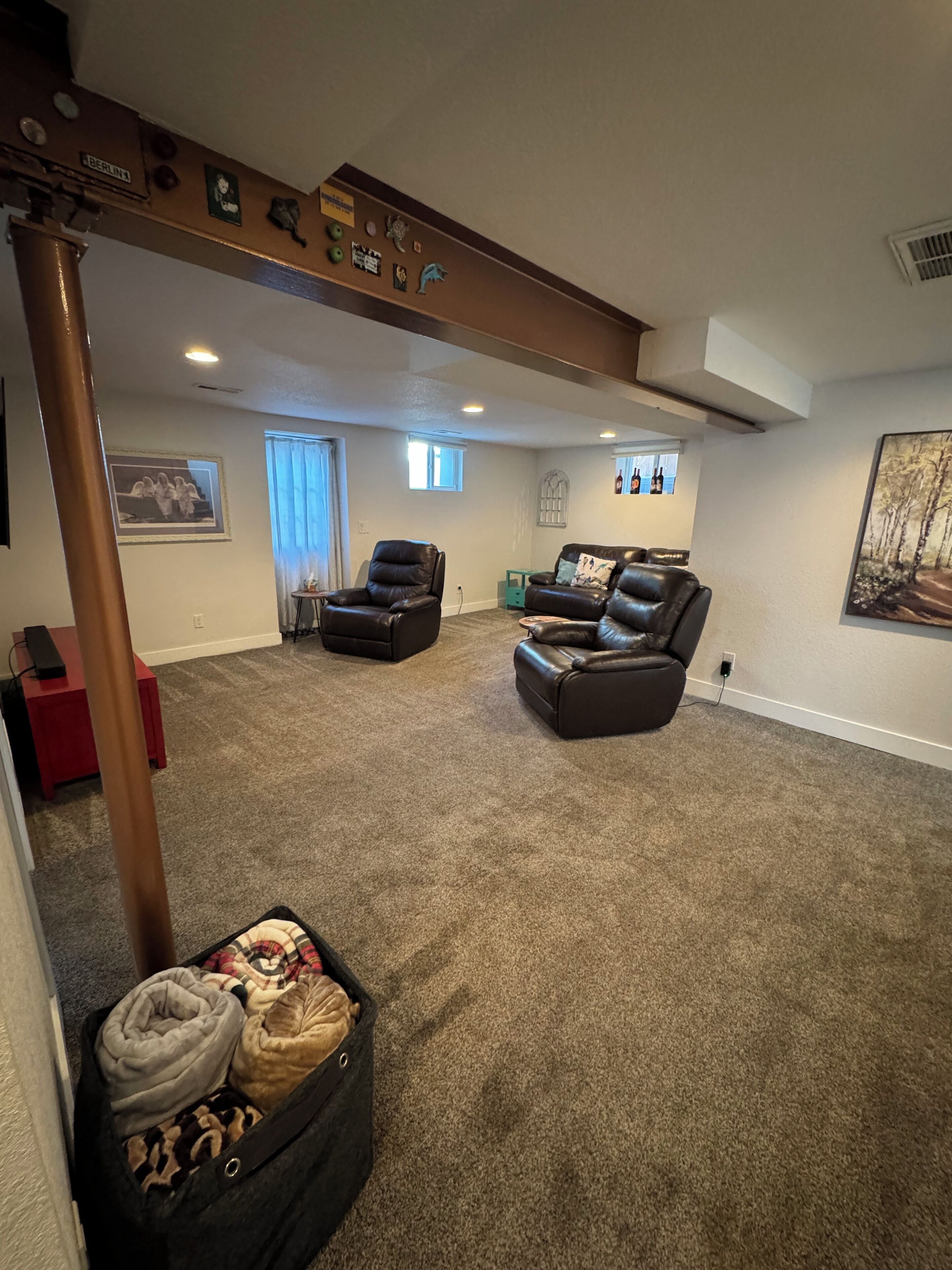 A spacious living room with a high ceiling, a fireplace, and a cozy seating area with leather sofas.