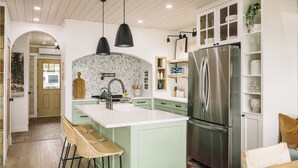 A modern kitchen with a central island, stainless steel appliances, and a rustic wooden ceiling. - Riverside Cabin 4
A serene riverside getaway (Campbellford)