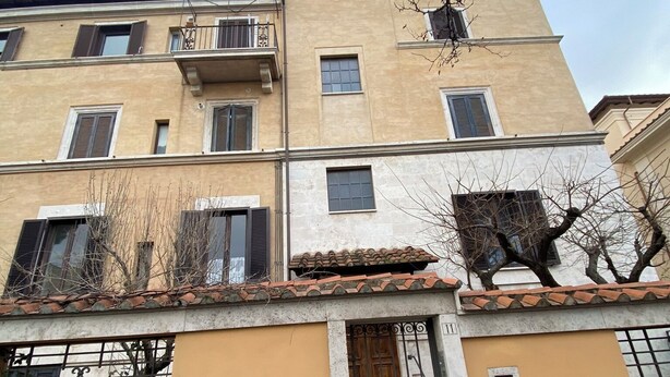 A multi-story building with a beige facade, a tiled roof, and a gated entrance. - Under Trastevere stars - Live like a local on Gianicolo hill! (Roma)