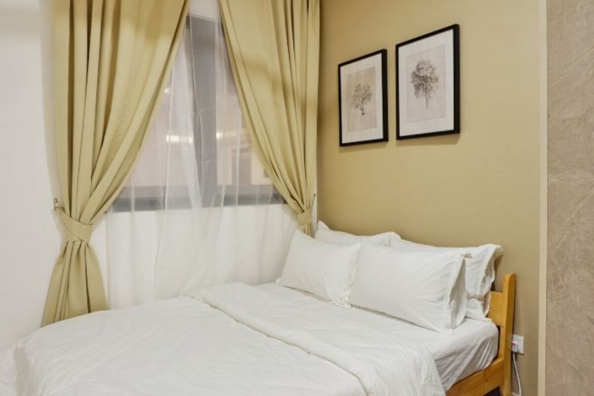 Una cama bien hecha con ropa de cama blanca, un cabecero de madera y dos cuadros en la pared.