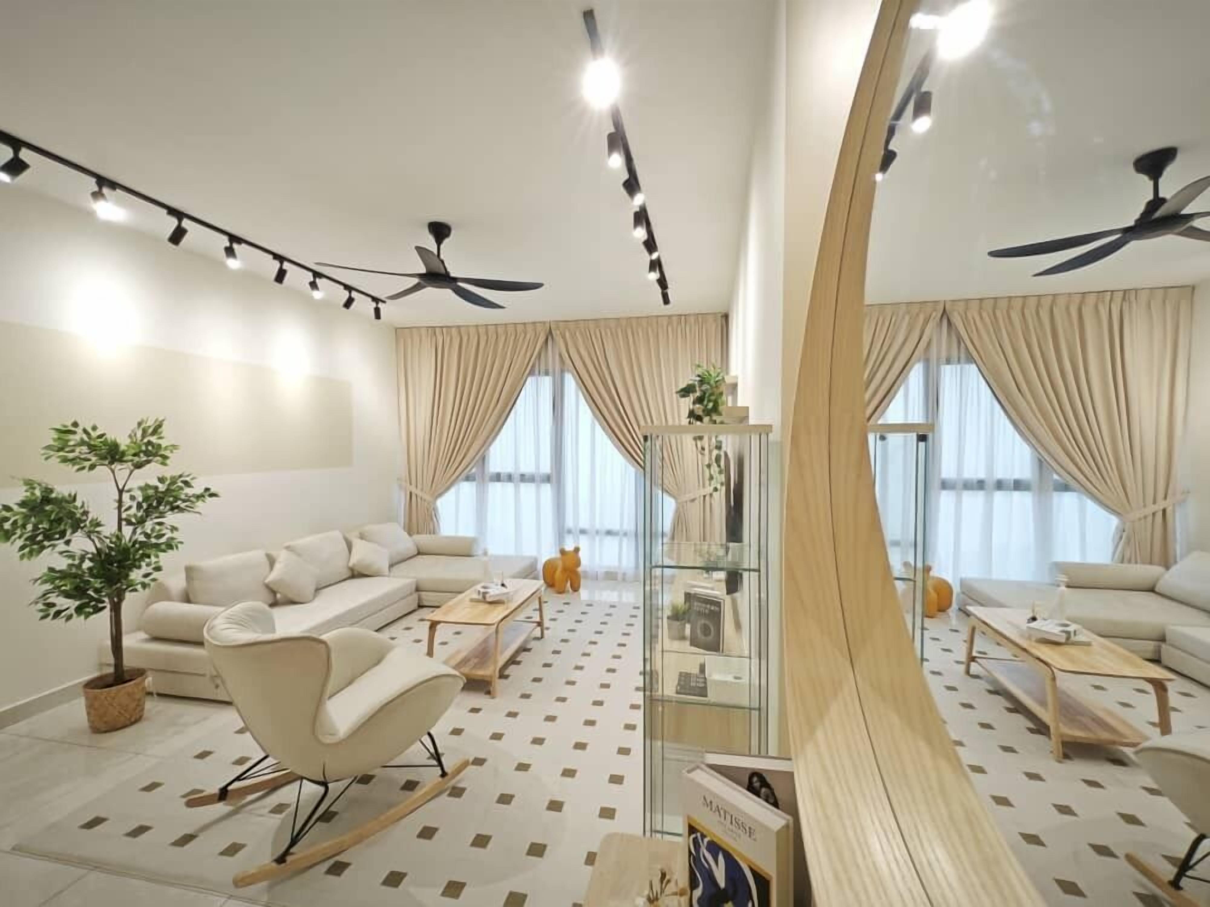 A modern living room with a sectional sofa, a rocking chair, and a glass coffee table. There are ceiling fans, a large window with curtains, and a potted plant.