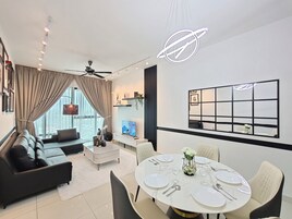 A modern living room with a sofa, coffee table, and dining area set for six.
