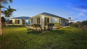 Una casa moderna con techo plano, ventanas amplias y un césped cuidado.