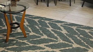 A dining area with a glass table and chairs, a small plant on the table, and a patterned rug on the floor. - Cozy, peaceful, very clean, you can work or just get away, weekly or monthly.   (Jacksonville)