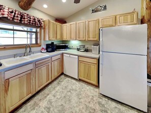 A kitchen with wooden cabinets, a white refrigerator, a sink, a microwave, and a coffee maker. - 4 Bears 1 Cave by Ruidoso Vacation Rentals (Alto)