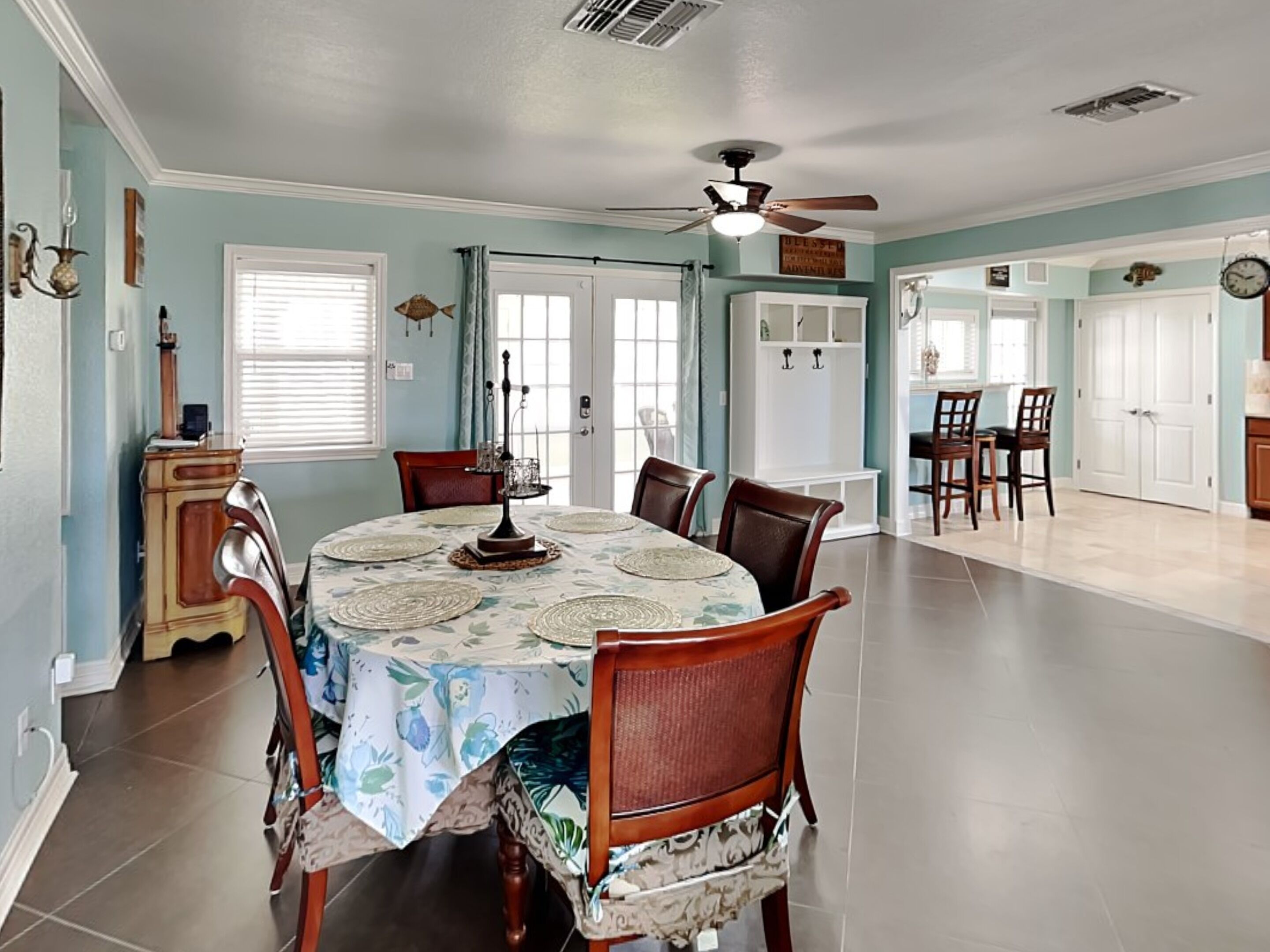 A dining room with a round table, chairs, and a ceiling fan.