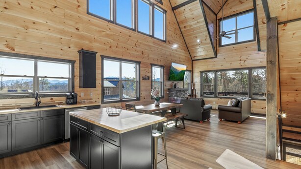 A spacious kitchen with a large island, a dining area with a sofa, and a living room with a fireplace.