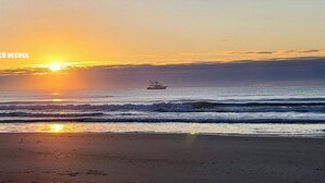 A sunrise from beach access with a boat in the distance. - "Gay Dayz"4 bed/3.5bath w/pool/beach access (North Topsail Beach)