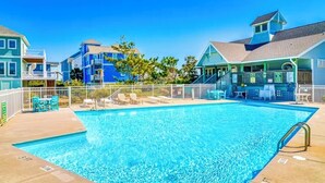 A swimming pool with lounge chairs and a fenced deck area. - "Gay Dayz"4 bed/3.5bath w/pool/beach access (North Topsail Beach)