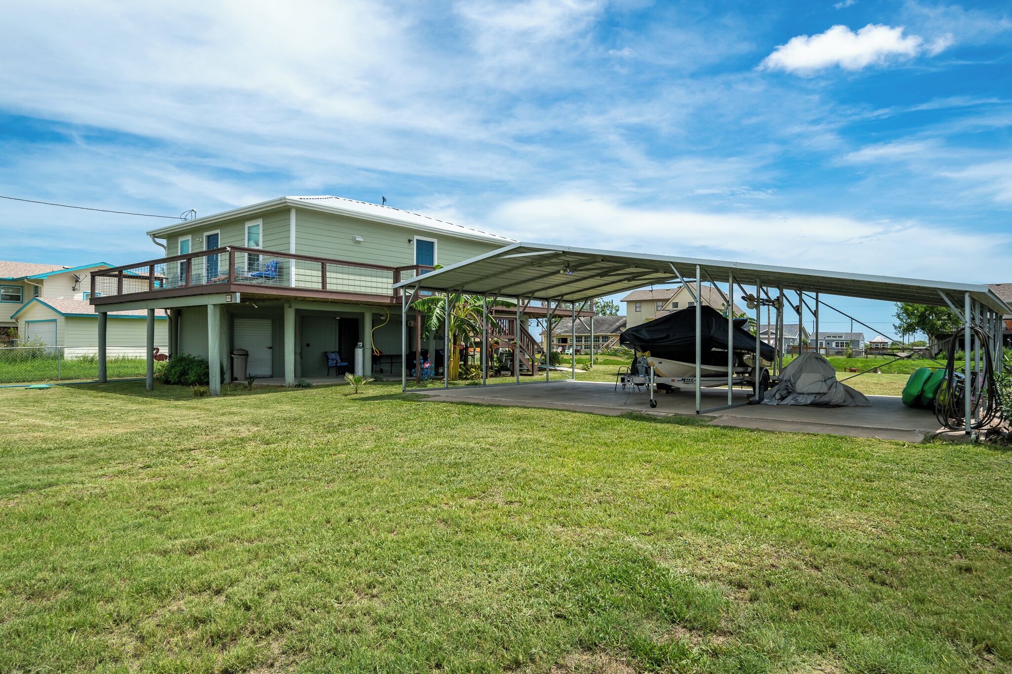 Ein Haus mit überdachter Terrasse, Garage und kleinem Garten.
