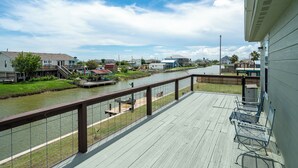 Une propriété située au bord de l’eau, dotée d’une terrasse en bois, d’une vue sur la rivière et d’un petit quai.