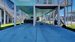 Ein überdachter Gang mit Sitzgelegenheit und einer Treppe zu einem erhöhten Deck.