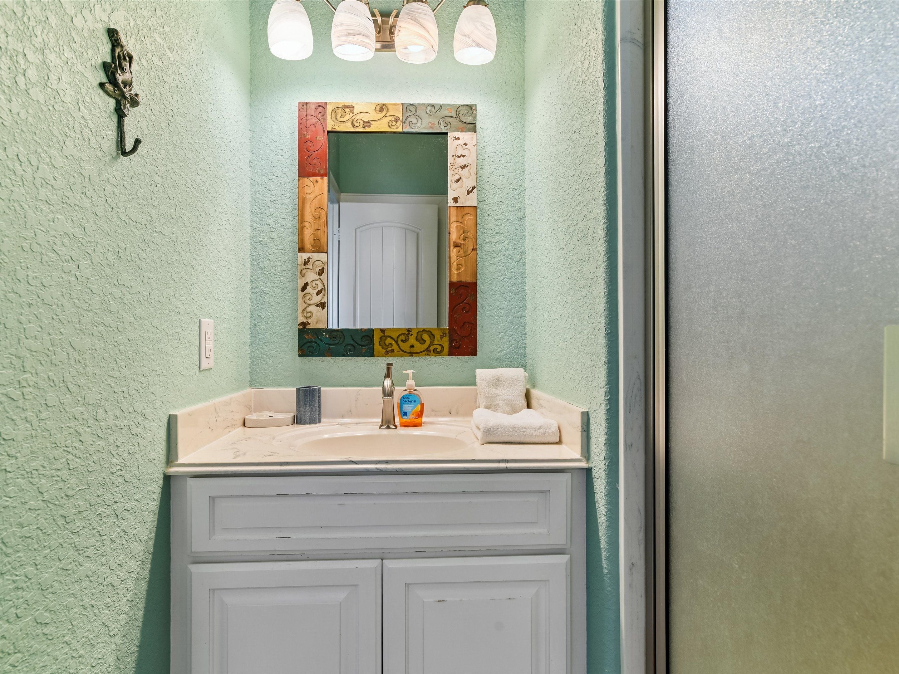 A bathroom with a sink, a mirror, and a towel.