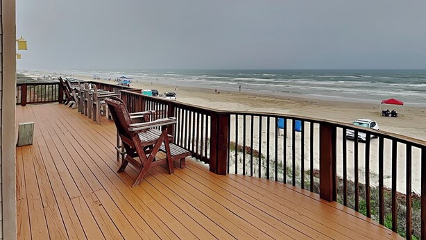 A wooden deck with a railing overlooking a beach. - Seaside Eden by Ryson Vacation Rentals (Freeport)