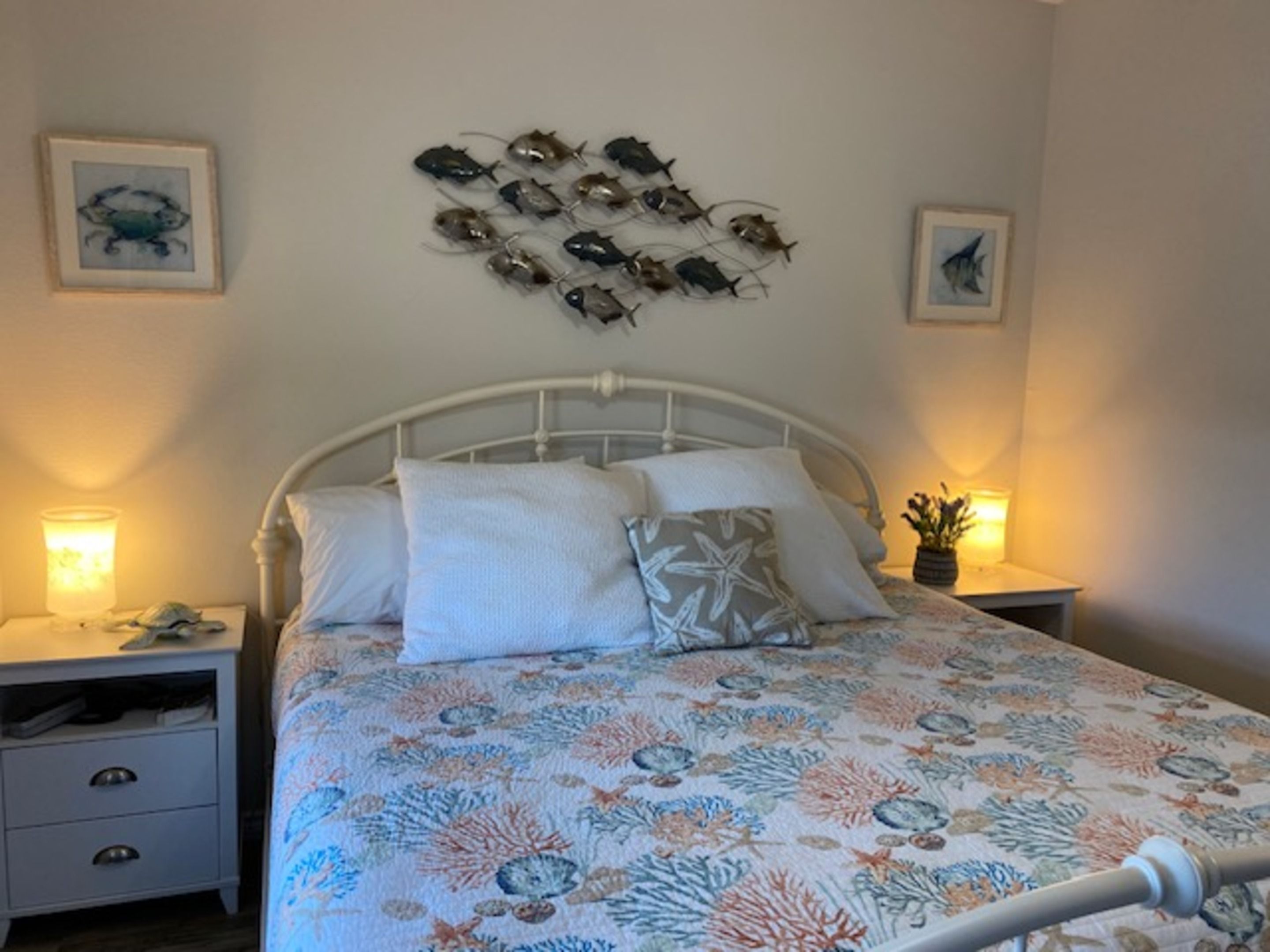 Un dormitorio con una cama, dos mesitas de noche y una obra de arte en la pared.