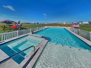 A swimming pool with a view of the surrounding area, including a flag and a flagpole. - Splish Splash Oasis by Ryson Vacation Rentals (Galveston)