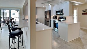 Een moderne keuken met witte kasten, roestvrijstalen apparatuur en een centraal eiland.