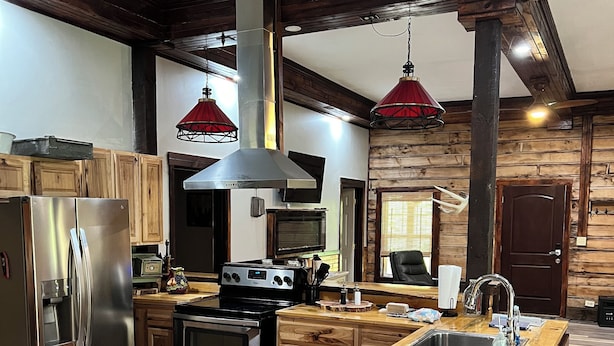 Una cocina moderna con armarios de madera, electrodomésticos de acero inoxidable y una isla central con un lavamanos.