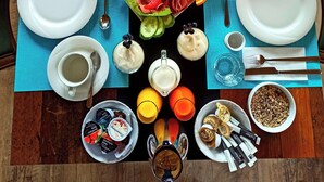 Una mesa de comedor bien dispuesta con diversos alimentos, bebidas y utensilios.