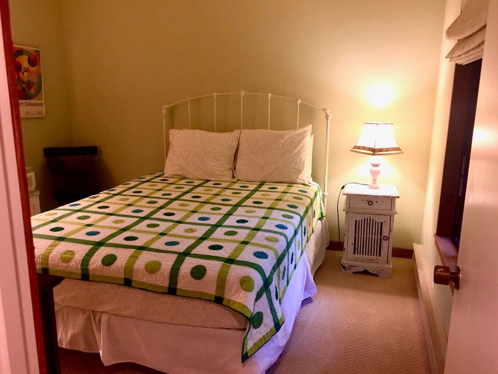 Ein Schlafzimmer mit einem Bett, einem Nachttisch und einer Lampe.