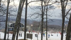 A snowy outdoor area with a building in the background. - Prime Location! Ski In, Ski Out 3BDR plus bonus room, 3BA, Condo on Dobie (Wintergreen Resort)