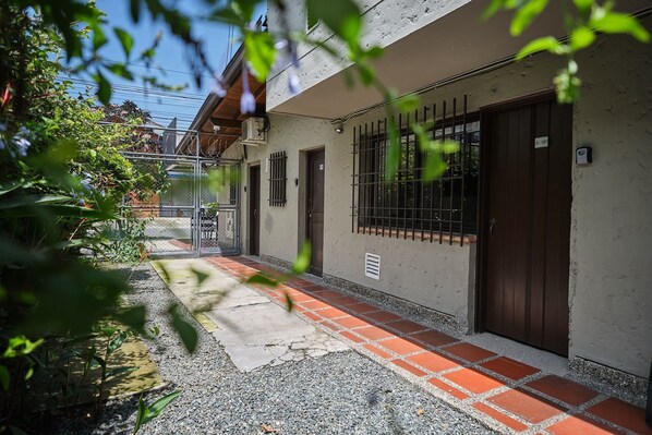 A building with a brick pathway leading to a gated entrance. - Poblado Aguacatala (Medellín)