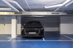 A parking garage with a black car parked in a designated space.