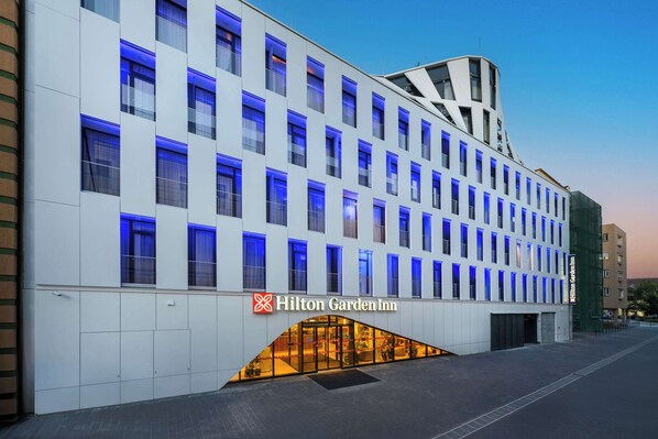 A modern hotel with a white facade and blue-lit windows. - Hilton Garden Inn Debrecen City Center (Debrecen)