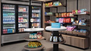 A hotel food display area with refrigerated beverages, snacks, and packaged foods. - Home2 Suites By Hilton Athens I 65 (Athens)