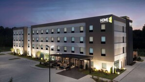 A modern hotel with a covered outdoor seating area, multiple floors, and a prominent "HOME 2" sign. - Home2 Suites By Hilton Athens I 65 (Athens)