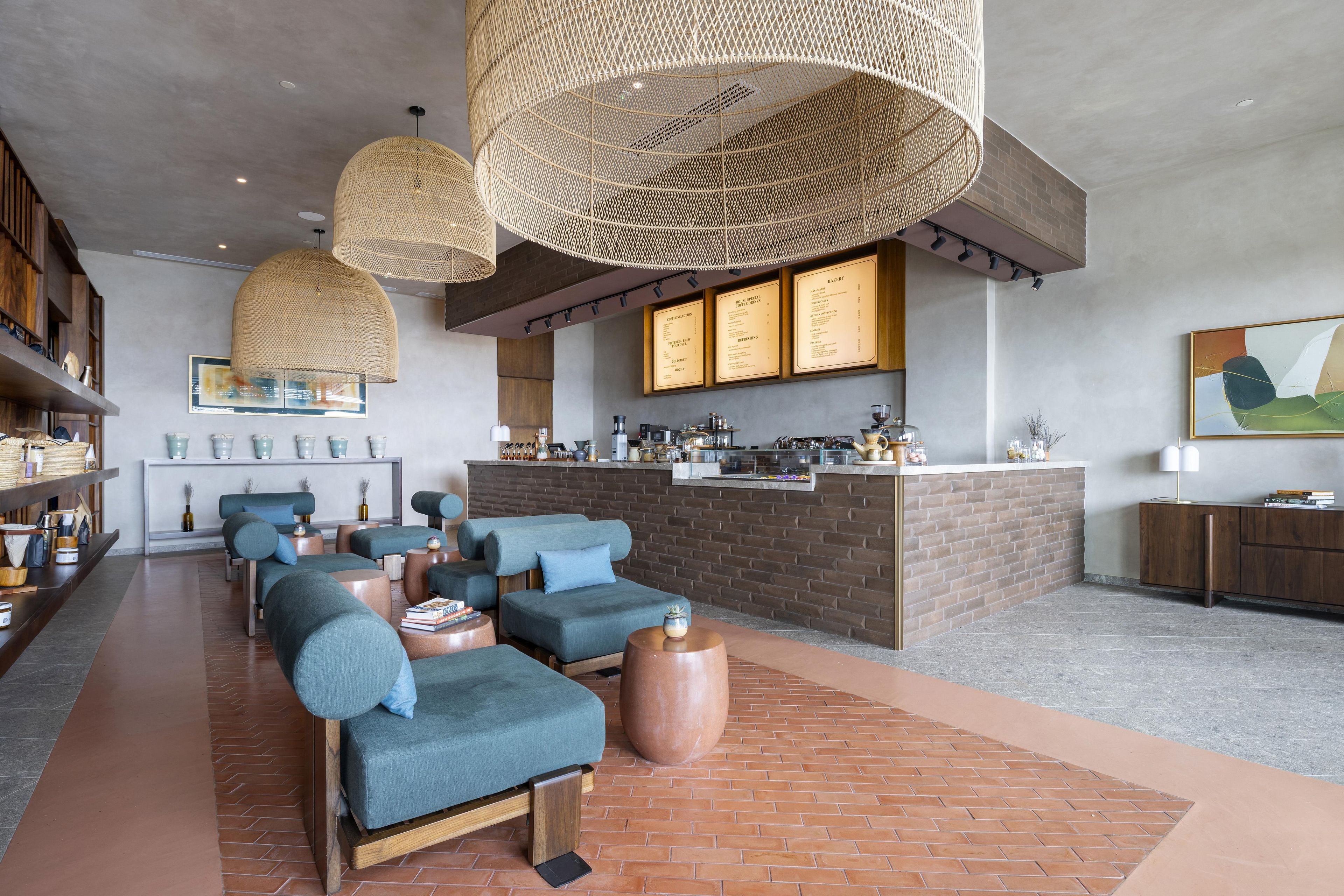 Uma área de estar moderna com sofás, um balcão de café e uma parede de tijolos.