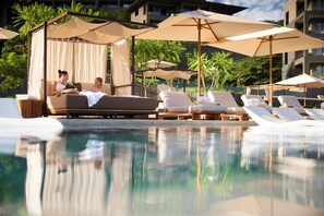 A poolside area with lounge chairs, umbrellas, and a canopy structure. - Waldorf Astoria Costa Rica Punta Cacique (Sardinal)
